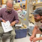 Photo by Sara Wilbur 
Knut Kielland, left, and Matt Kynoch look over age-count figures for marten, wolverines and lynx in Kiellands office during a recent interview. Coincidentally, Kynoch is wearing a T-shirt from the Coldfoot truck stop.